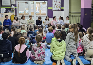 Dzieci słuchają głośno czytanego tekstu Szewczyka Dratewki
