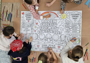 Dzieci kolorują wykonany plakat